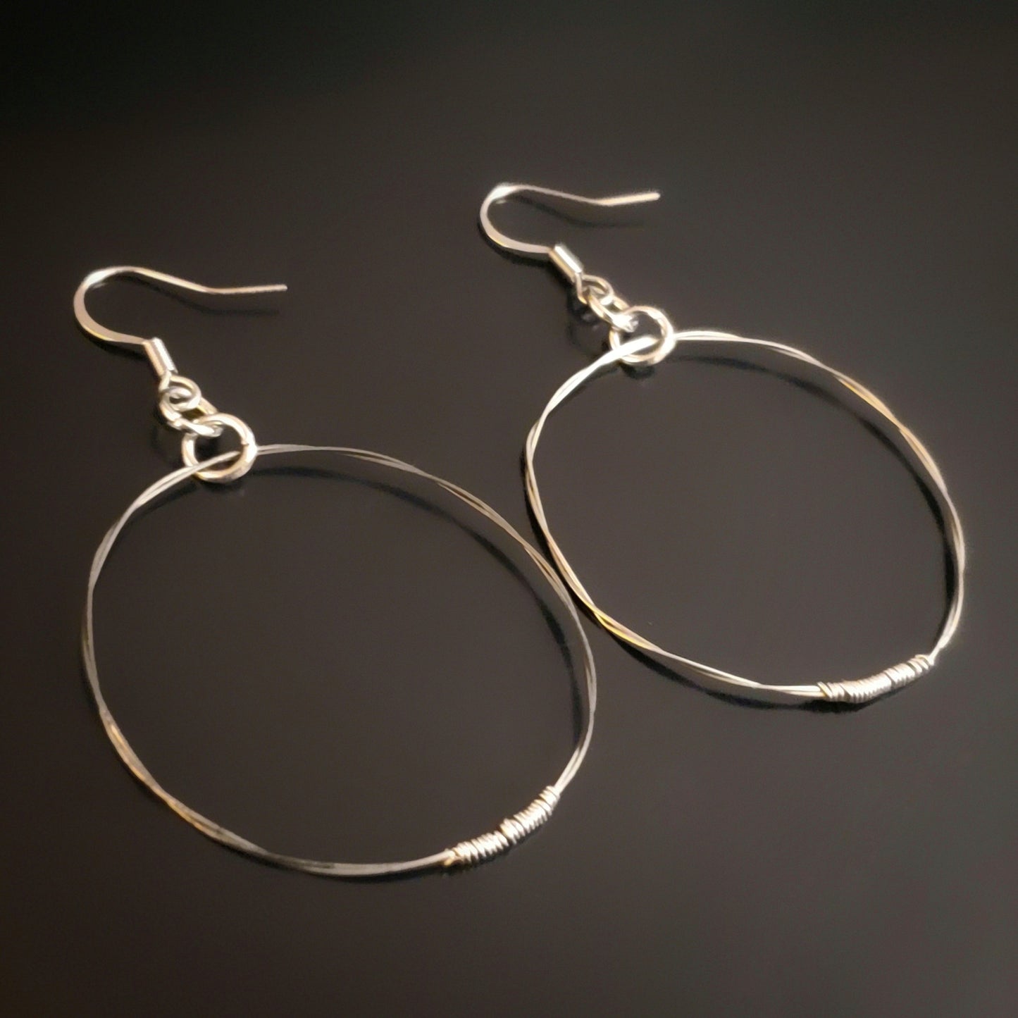 silver coloured hoop style earrings made from upcycled guitar strings