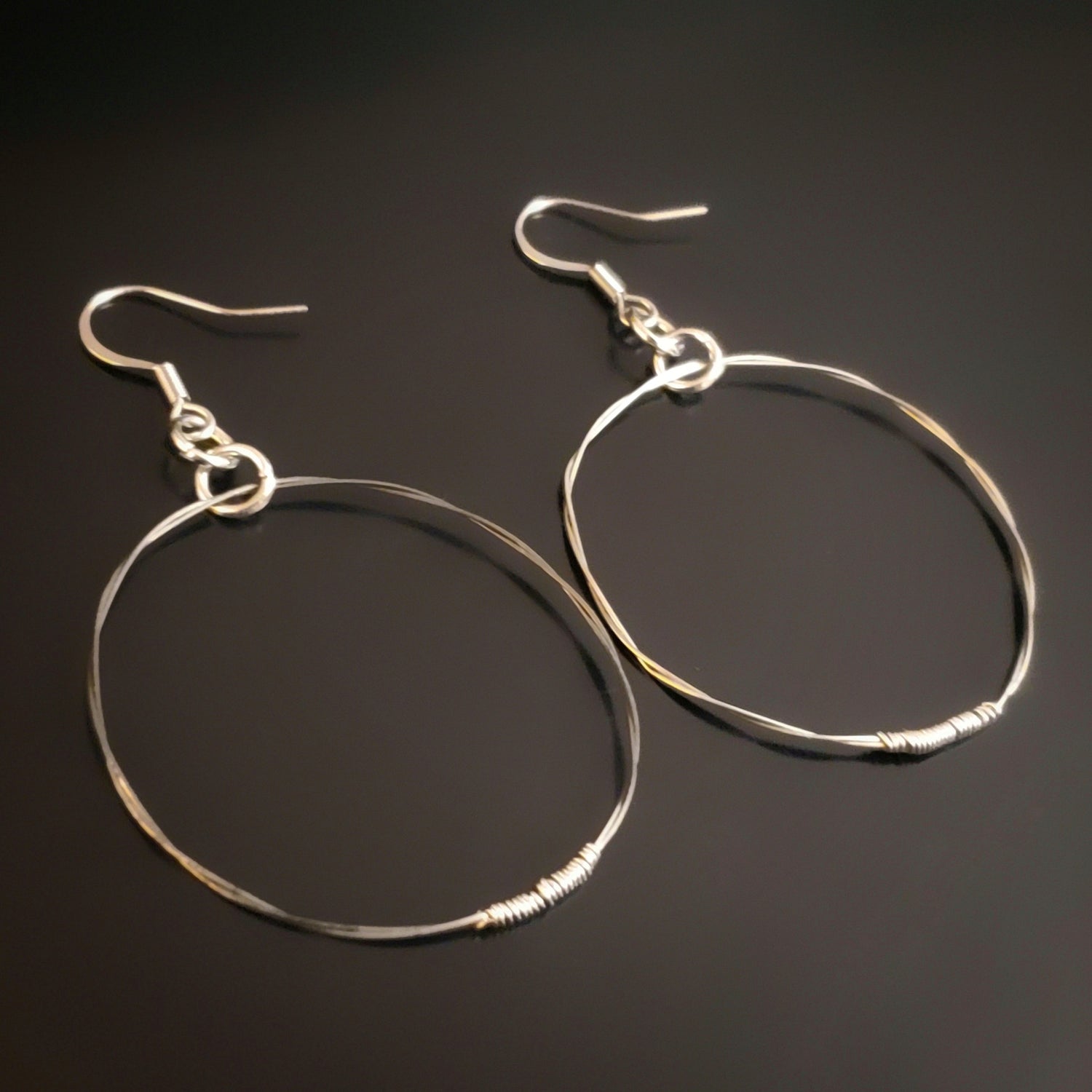 silver coloured hoop style earrings made from upcycled guitar strings