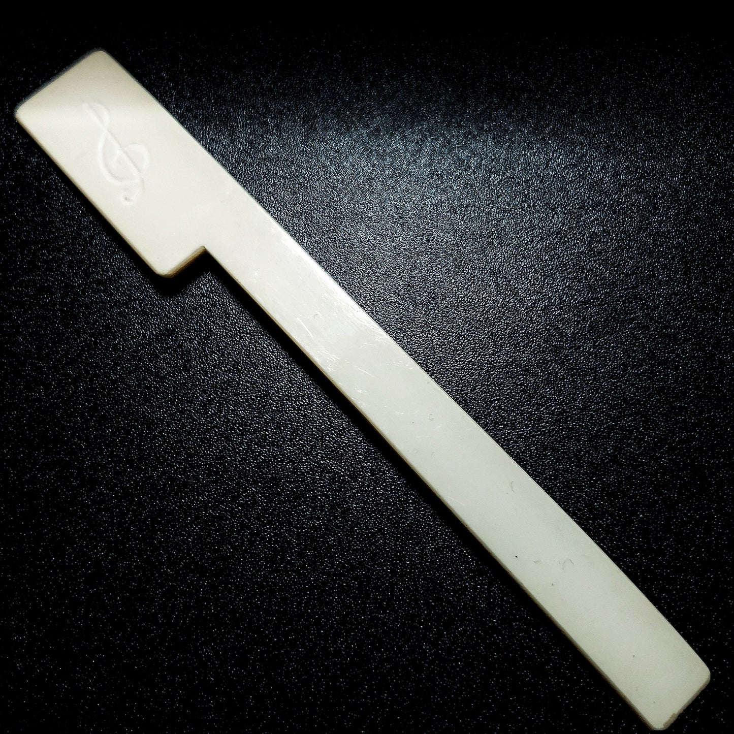 Bookmark made from a white piano key topper-a treble clef has been etched on it