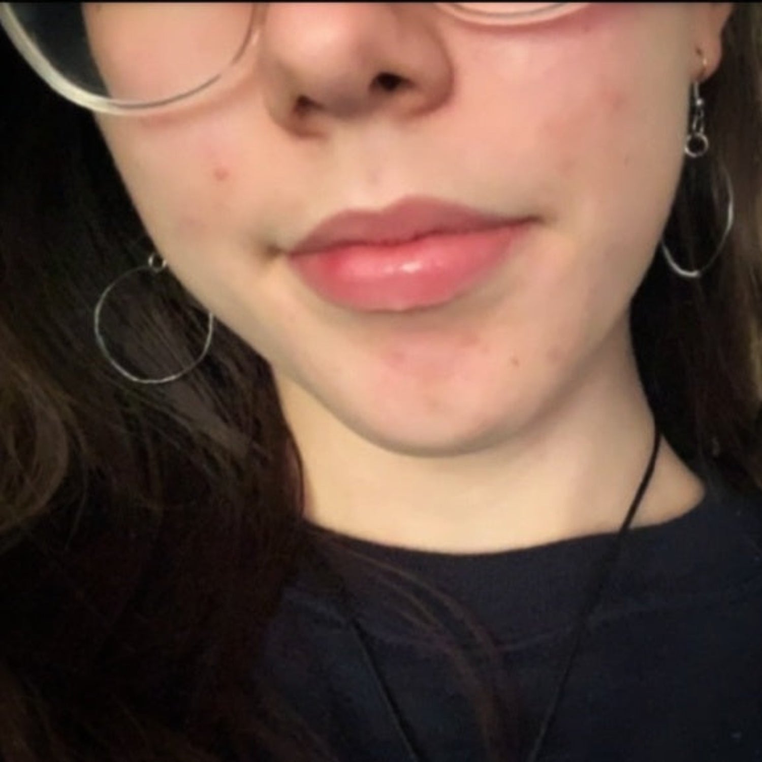 Lower part of woman's face with glasses and brown hair-wearing hoop drop style earrings made from upcycled guitar strings