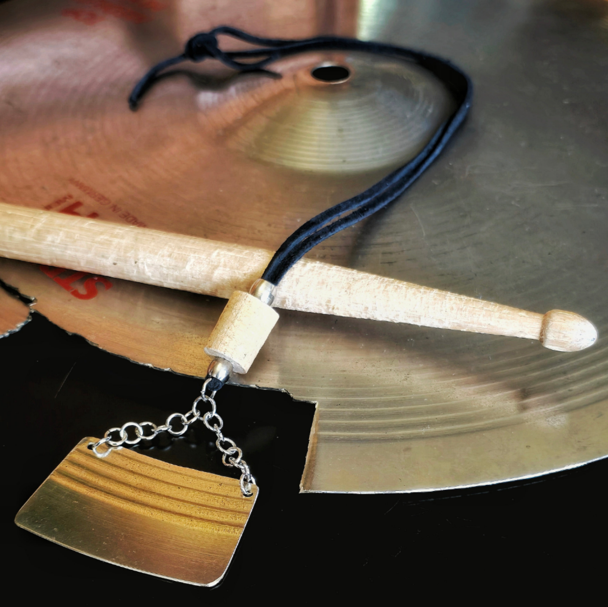 necklace made from black suede cord and upcycled cymbal and drumstick pieces