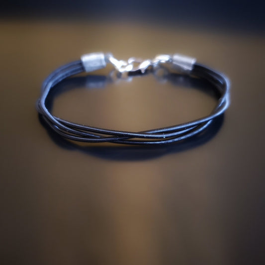 clasp style bracelet made from 3 upcycled  harp strings braided together
