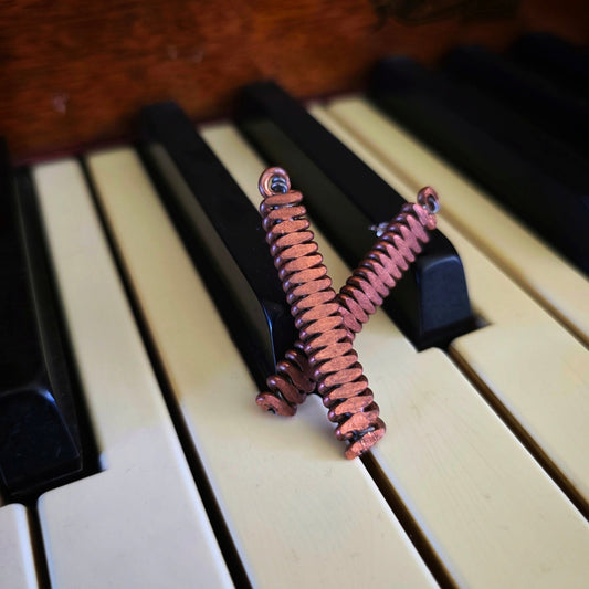 Upcycled Piano String Earrings on a piano