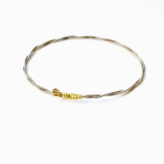 bangle style bracelet made from an upcycled guitar string - white background