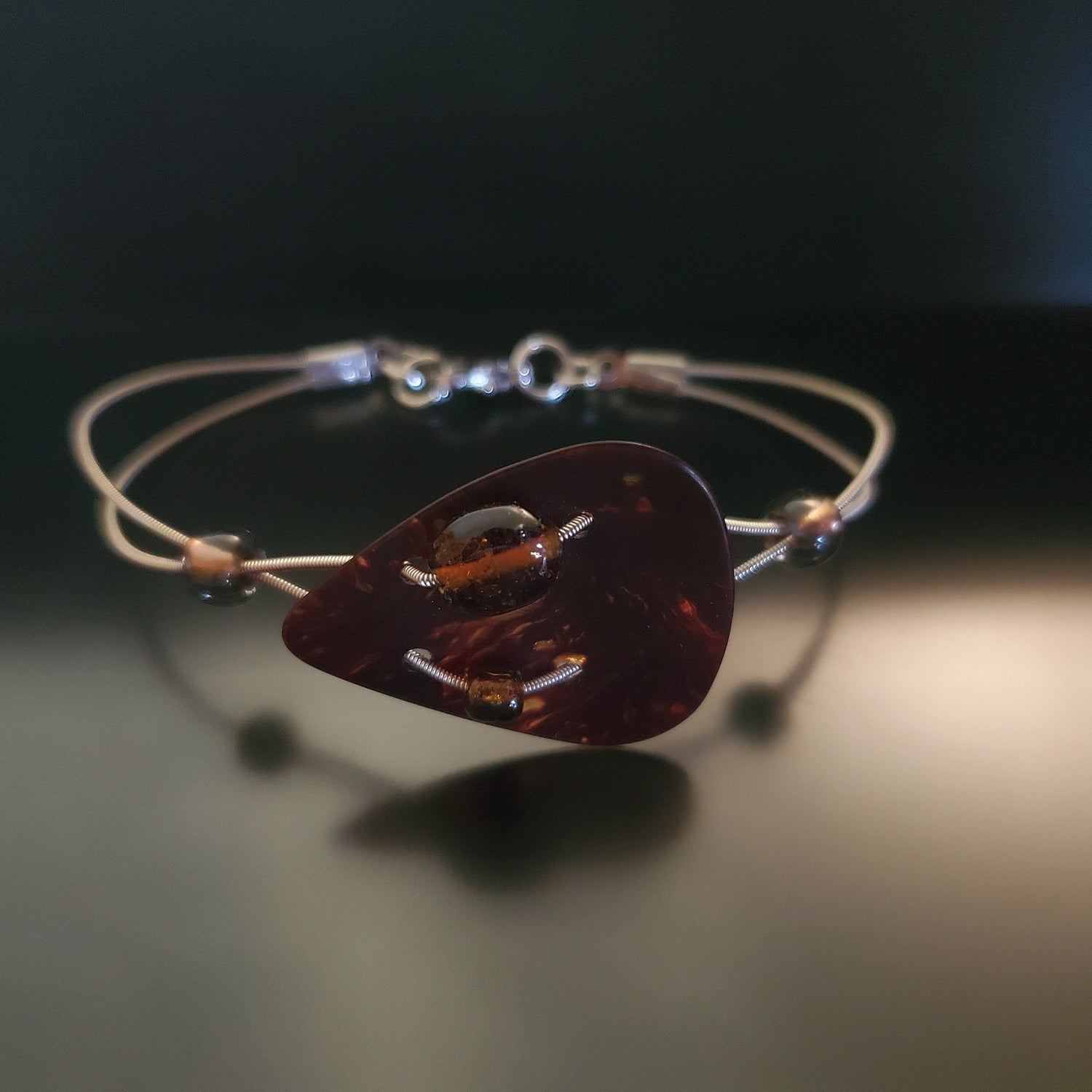 bracelet made from both upcycled guitar strings and a beautiful turtle shell brown guitar pick.