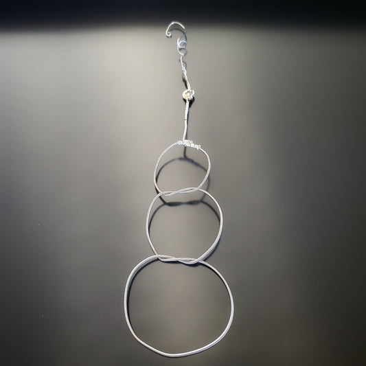 Christmas ornament in the shape of a snowman, made from an upcycled guitar string