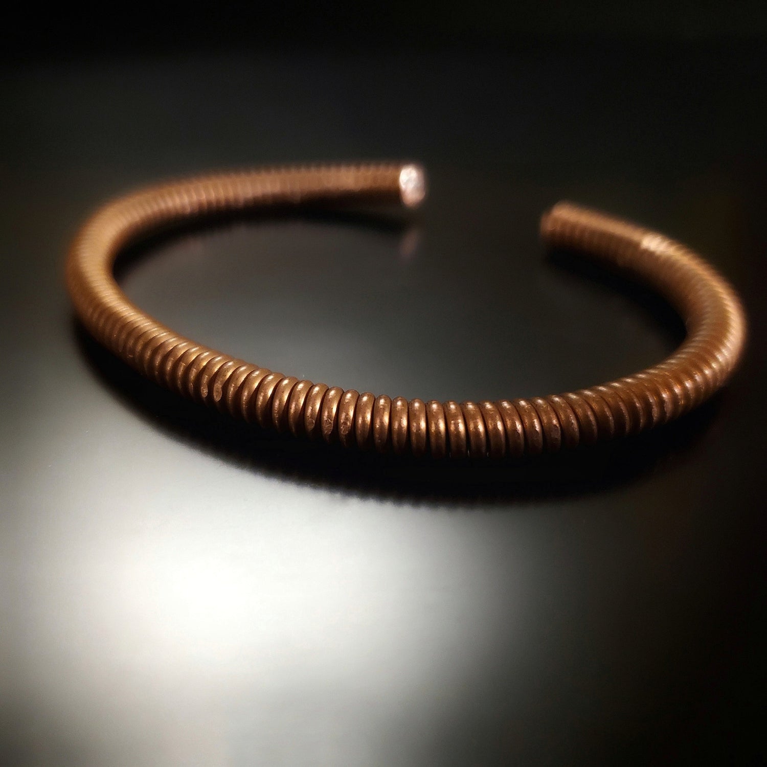 copper cuff style bracelet made from an upcycled piano string