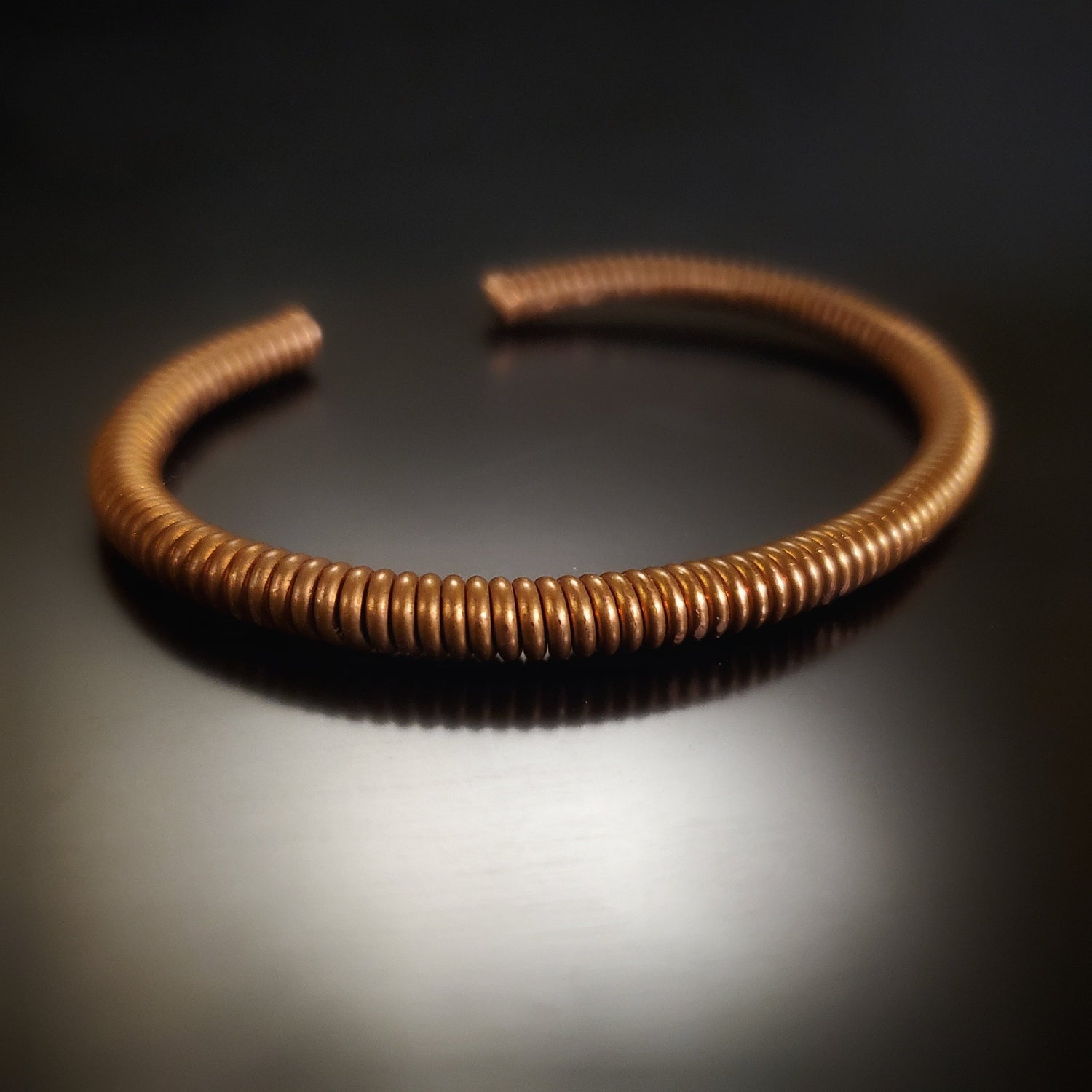copper cuff style bracelet made from an upcycled piano string