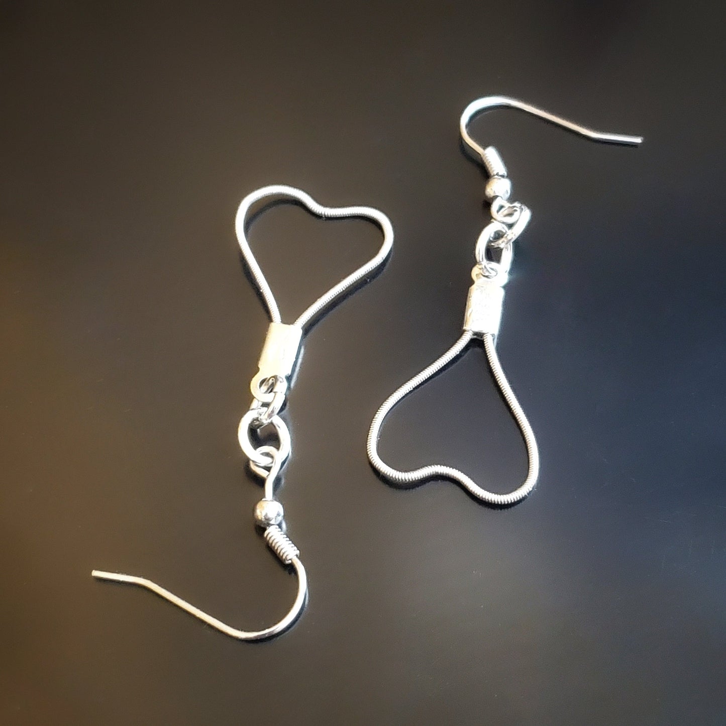 pair of heart shaped earrings made from upcycled guitar strings