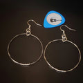 silver coloured hoop style earrings made from upcycled guitar strings - above is a blue guitar pick with a picture of a black guitar- black background
