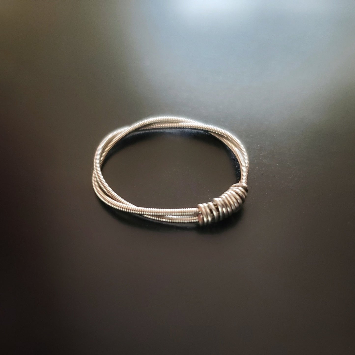 silver coloured guitar string ring with silver coloured wire