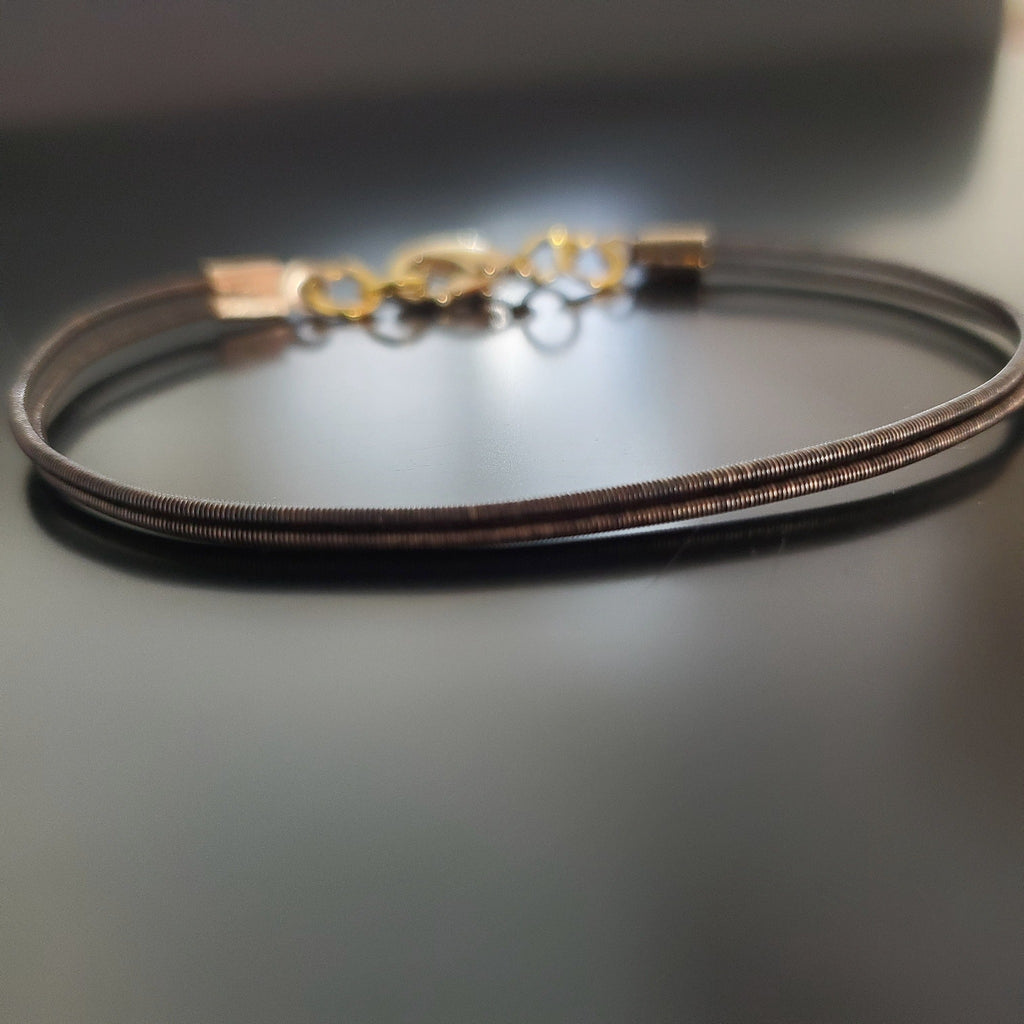 brown clasp style bracelet made from an upcycled harp string