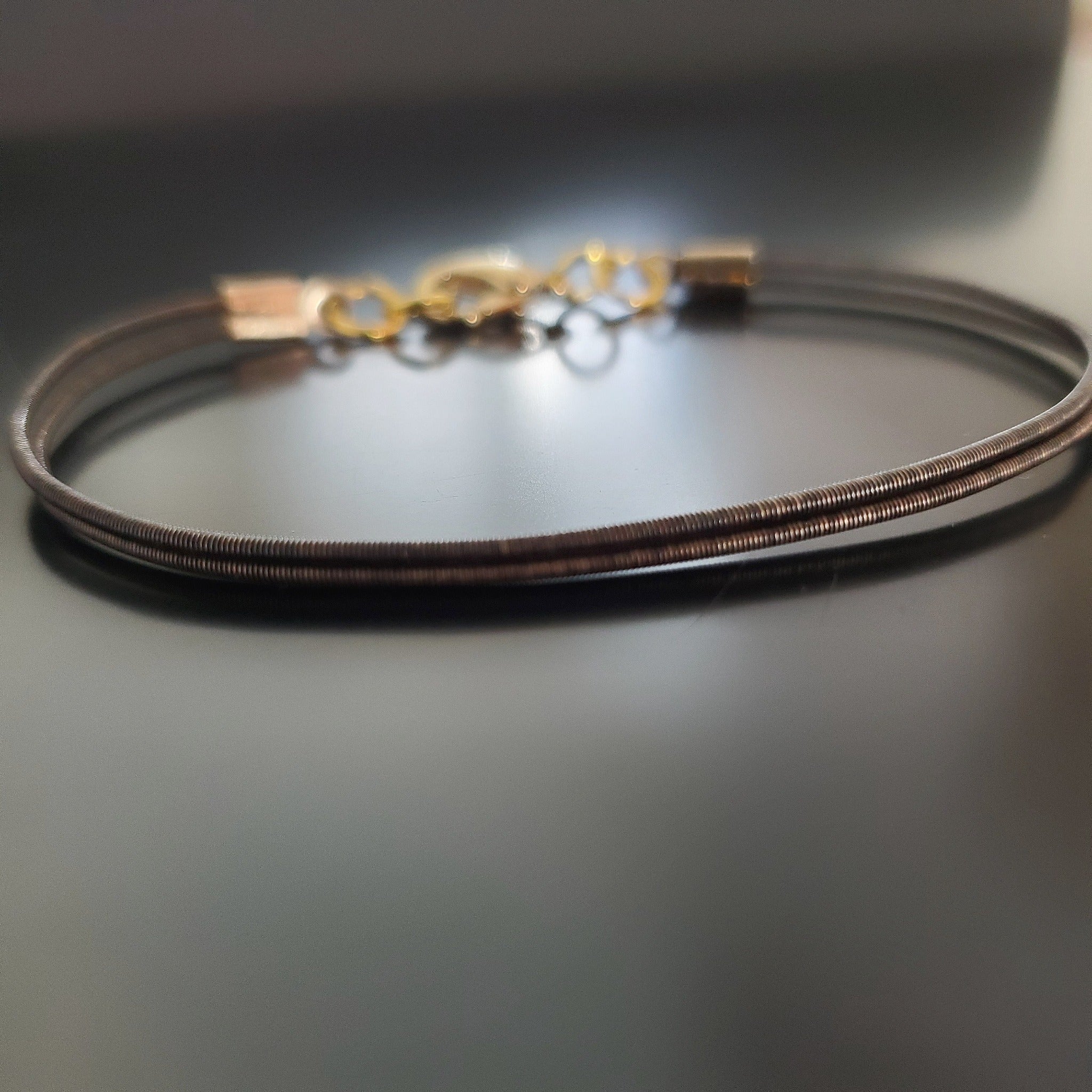 brown clasp style bracelet made from an upcycled harp string