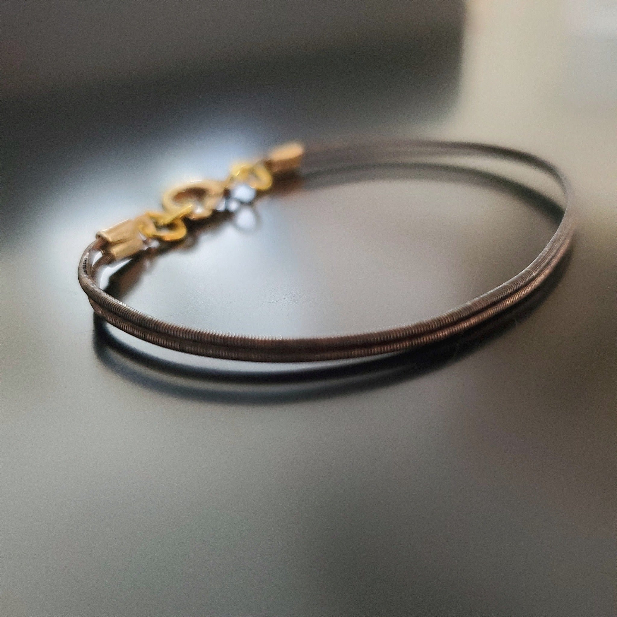 brown clasp style bracelet made from an upcycled harp string