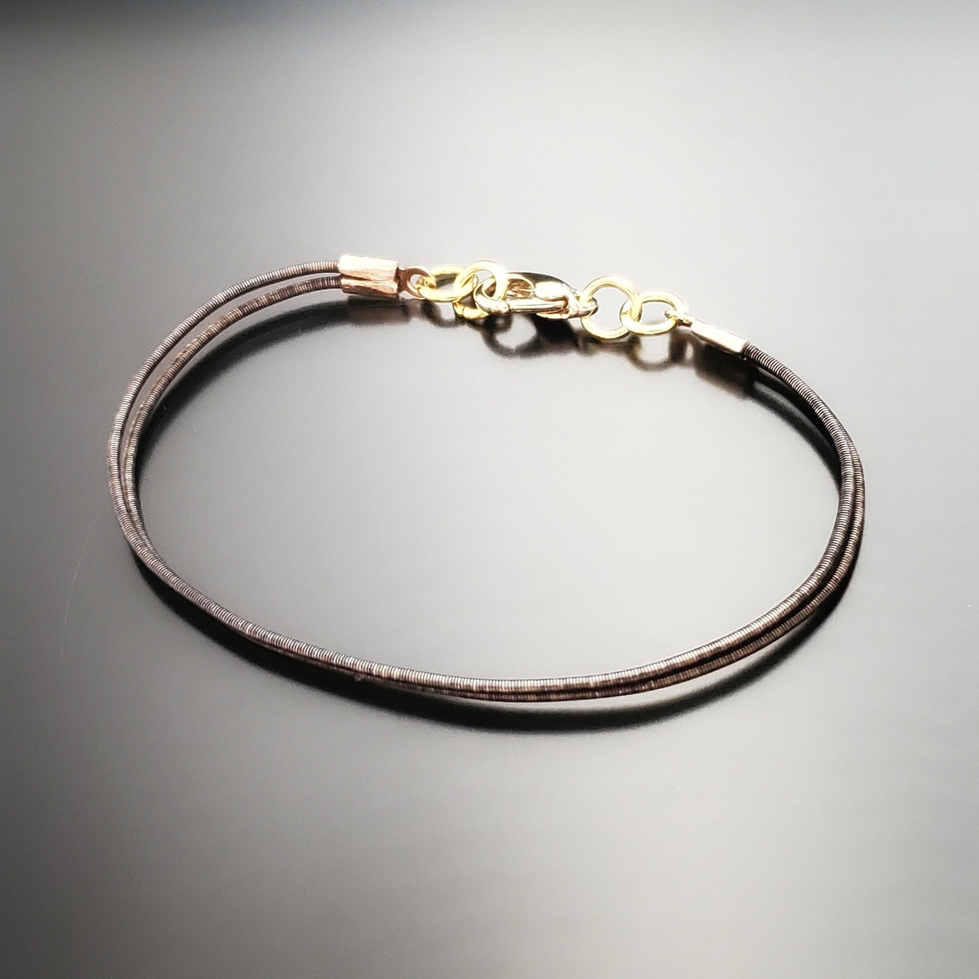 brown clasp style bracelet made from an upcycled harp string