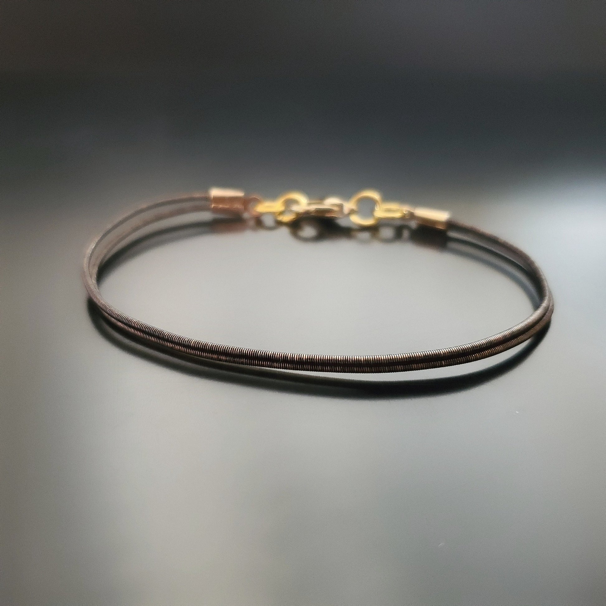 brown clasp style bracelet made from an upcycled harp string