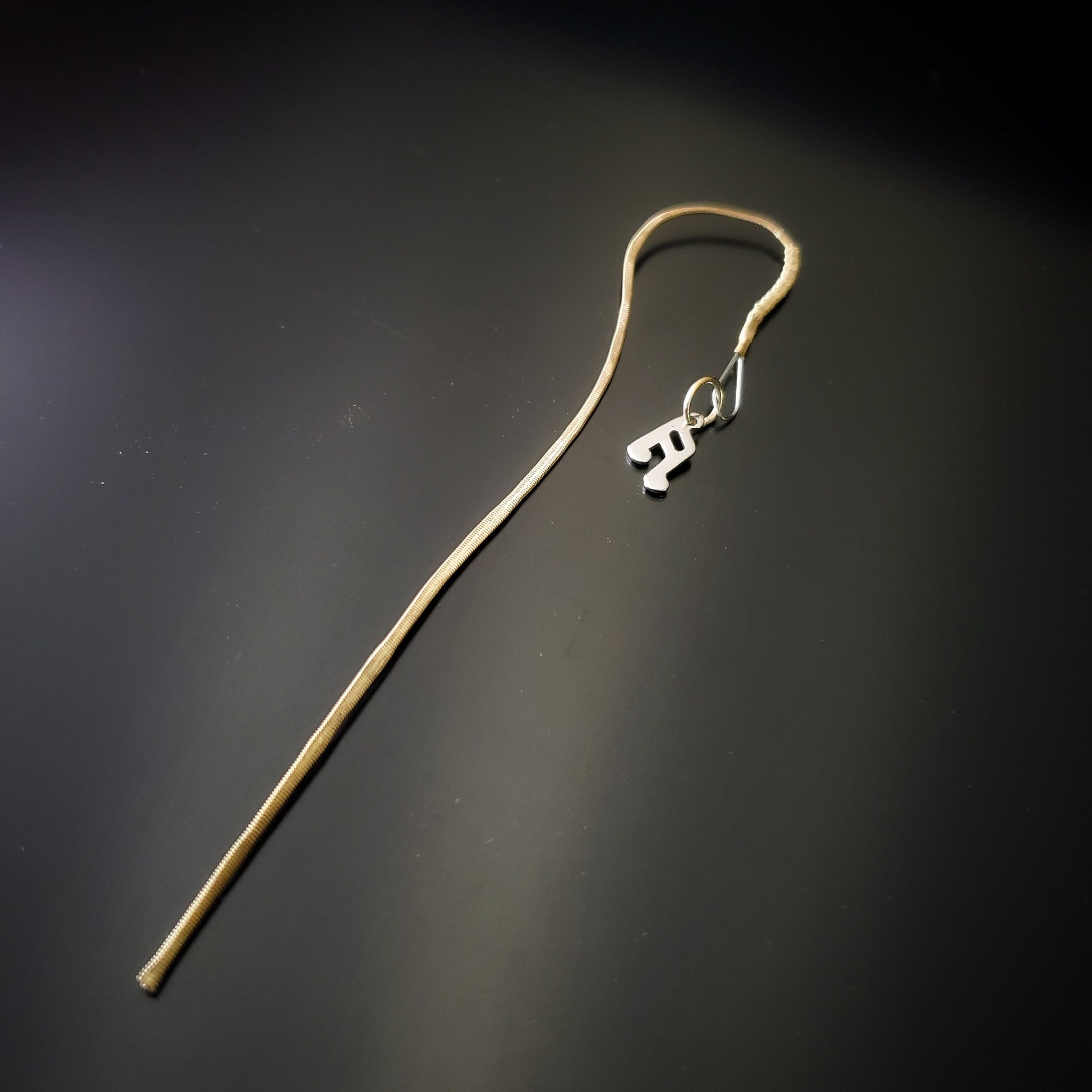 hook style bookmark made from an upcycled mandolin string and a silver quarter note shaped charm 
