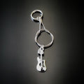 silver coloured keychain made from an upcycled guitar string - on it hangs a silver coloured electric guitar