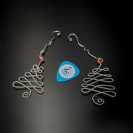 2 silver coloured christmas decorations in the shape of a christmas tree made from an upcycled guitar string  next to a light blue guitar pick