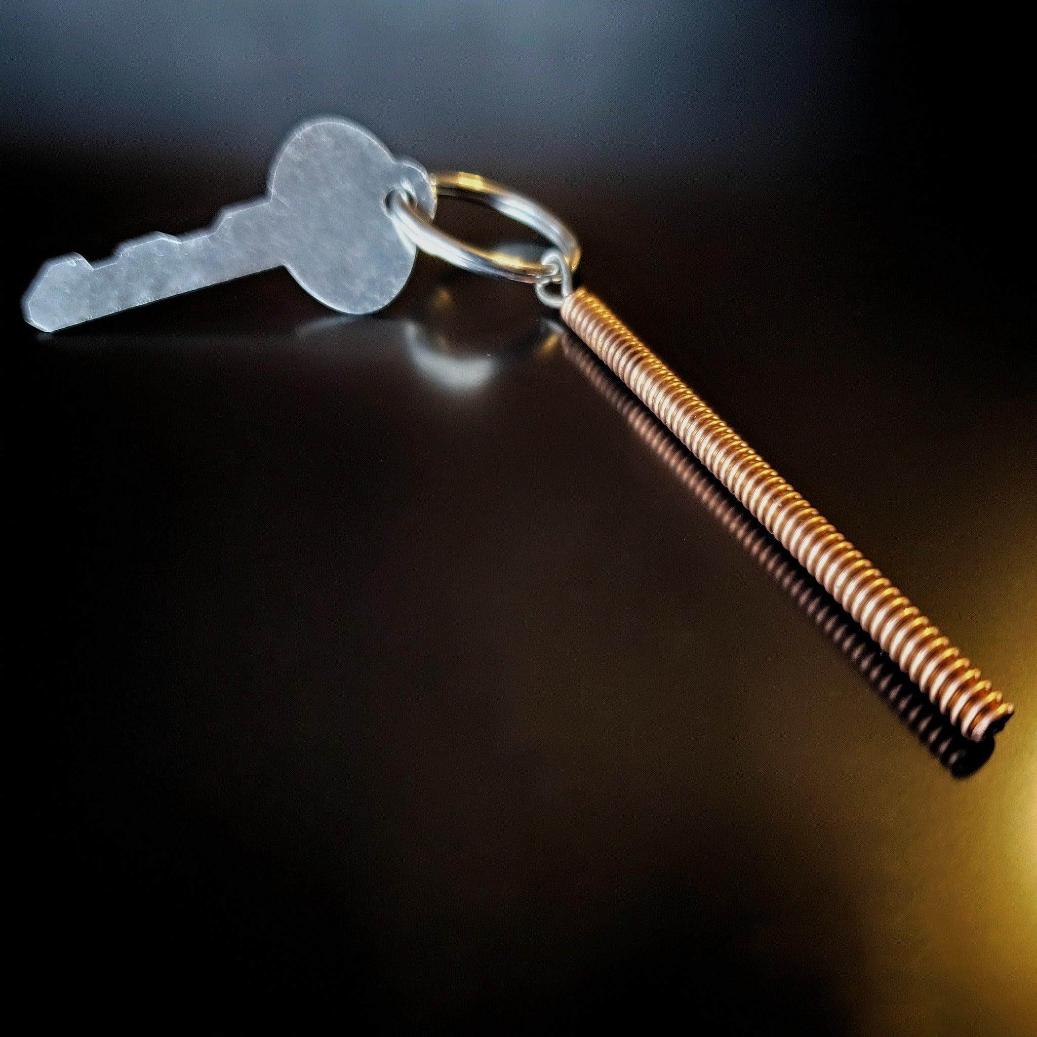 keychain made from a piece of piano string with a key attached