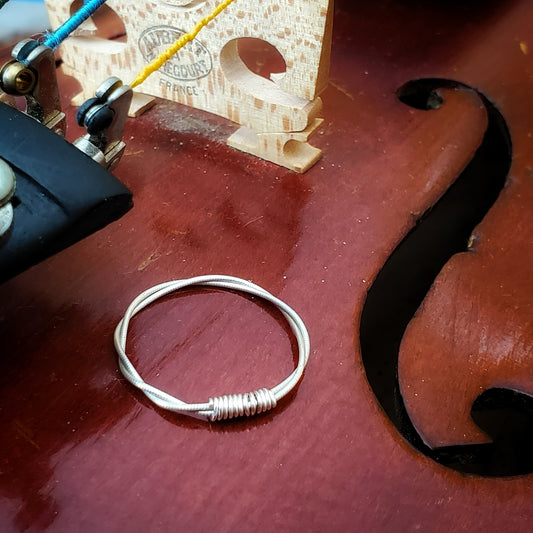 silver violin string ring on a violin