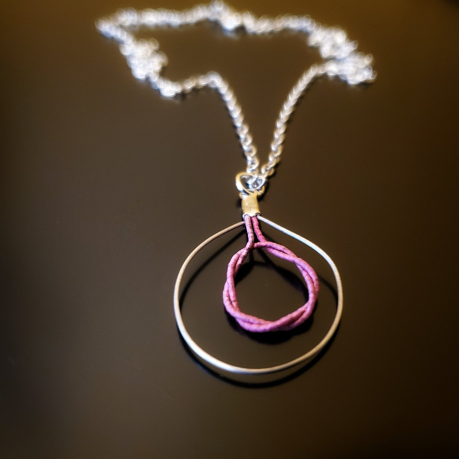 necklace with pink and silver colours on black background