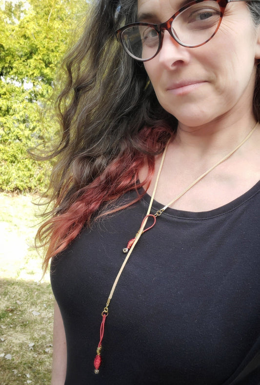 woman with long hair and glasses wearing a necklace made from upcycled harp strings and genuine suede