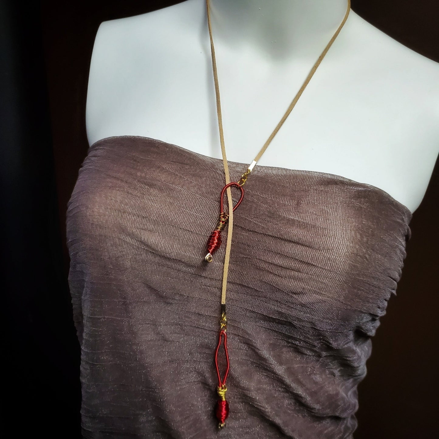 mannequin torso wearing an upcycled harp string and genuine suede necklace