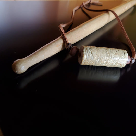 Upcycled Drumstick and Brown Suede Necklace With Wooden Beads lying on a drumstick