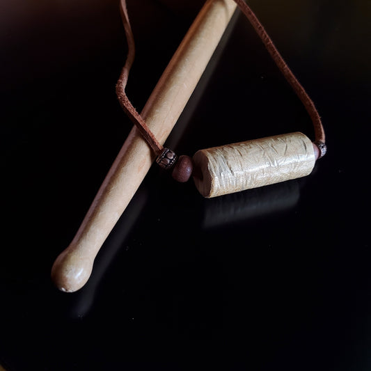 Upcycled Drumstick and Brown Suede Necklace With Wooden Beads lying on a drumstick