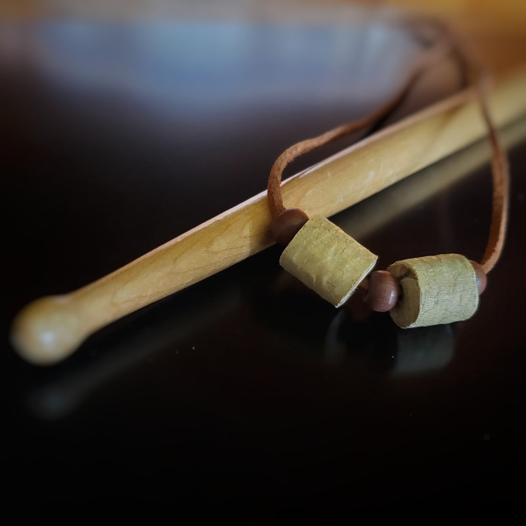 Upcycled Double Drumstick Beads and Brown Suede Necklace With Wooden Beads lying on a drumstick