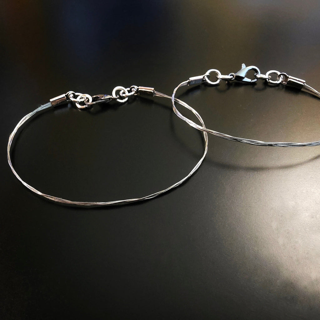2 violin string bracelets on black background