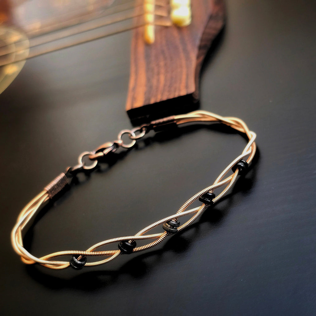 Braided Bronze Guitar String Black Ballend Unisex Bracelet on Black Guitar Body