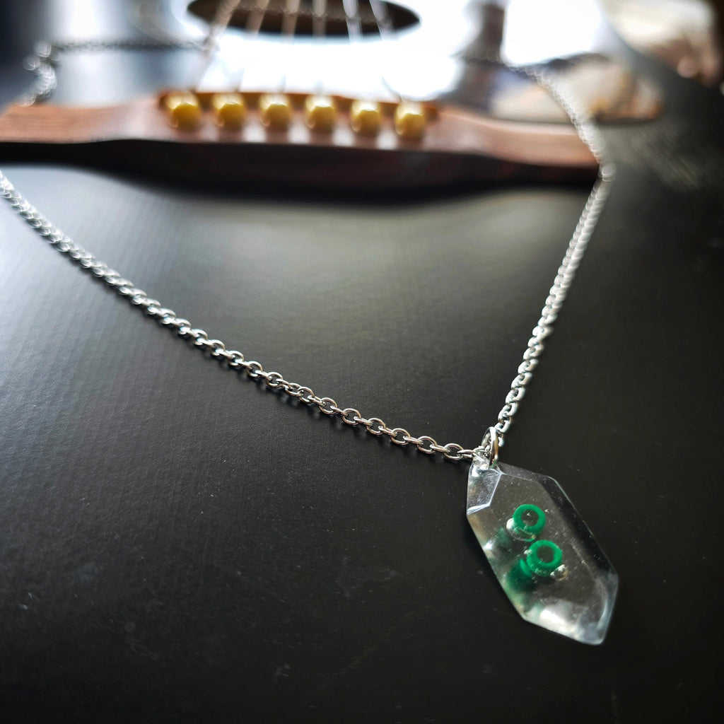 Close-up of Hexagone Resine Pendant with Green Guitar String Ballends Necklace
