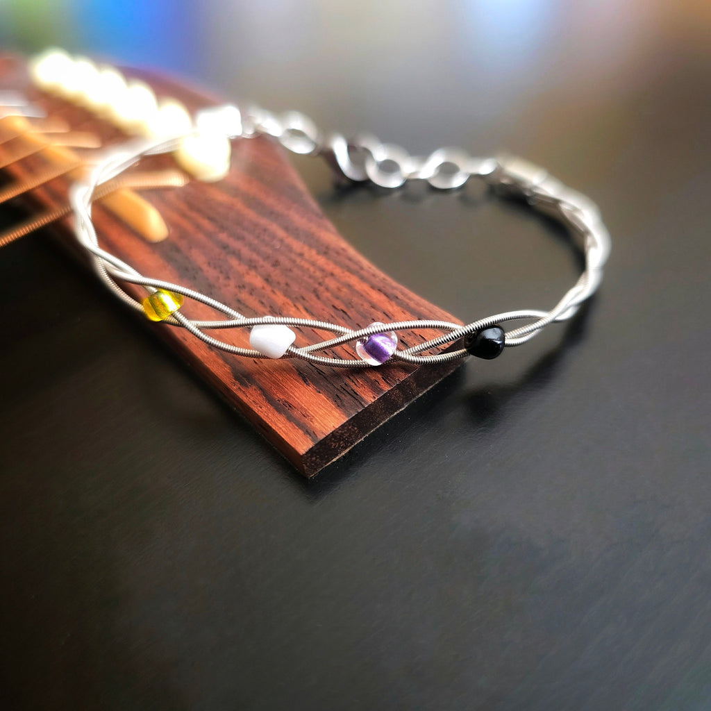 Close-up of Non-Binary Pride Three Guitar String Braided Clasp Bracelet