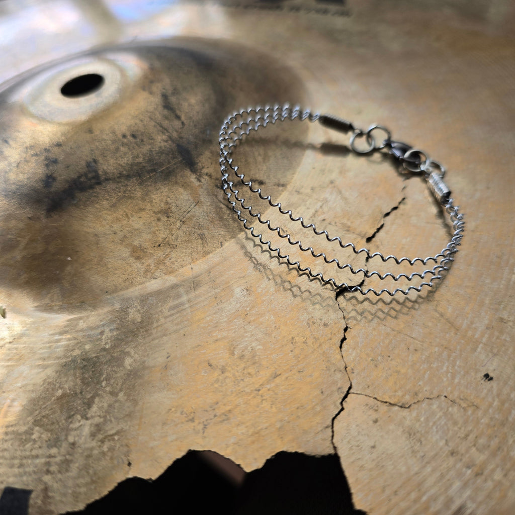 Close-up of Upcycled 3 String Snare Drum Bracelet on Cymbal 