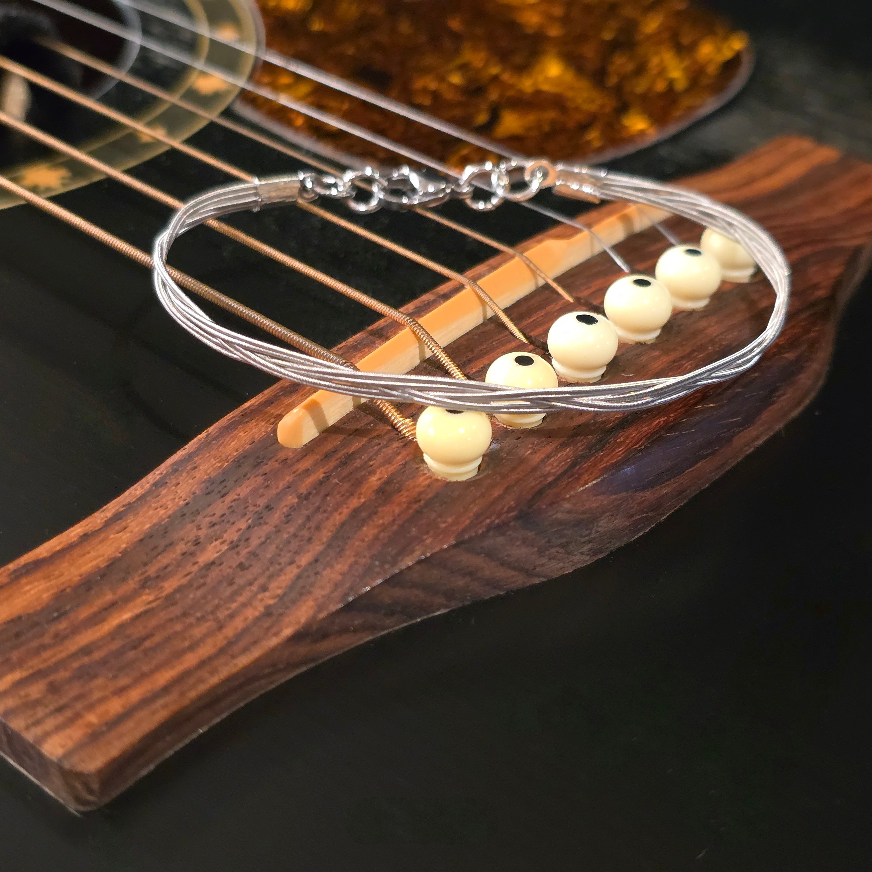 Close-up of a guitar's soundhole with a guitar sting bracelet on top