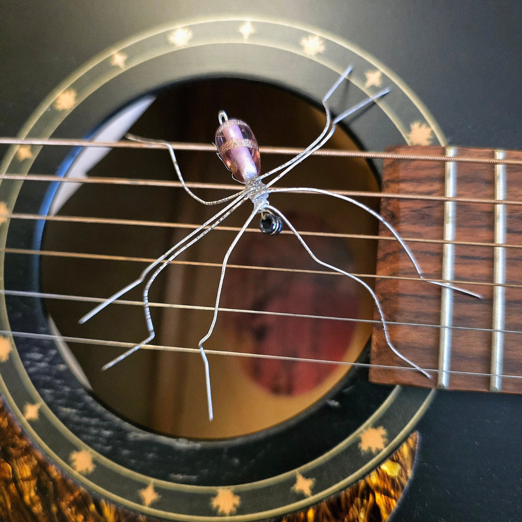 Close-up of a  guitar string spider decoration on an acoustic guitar