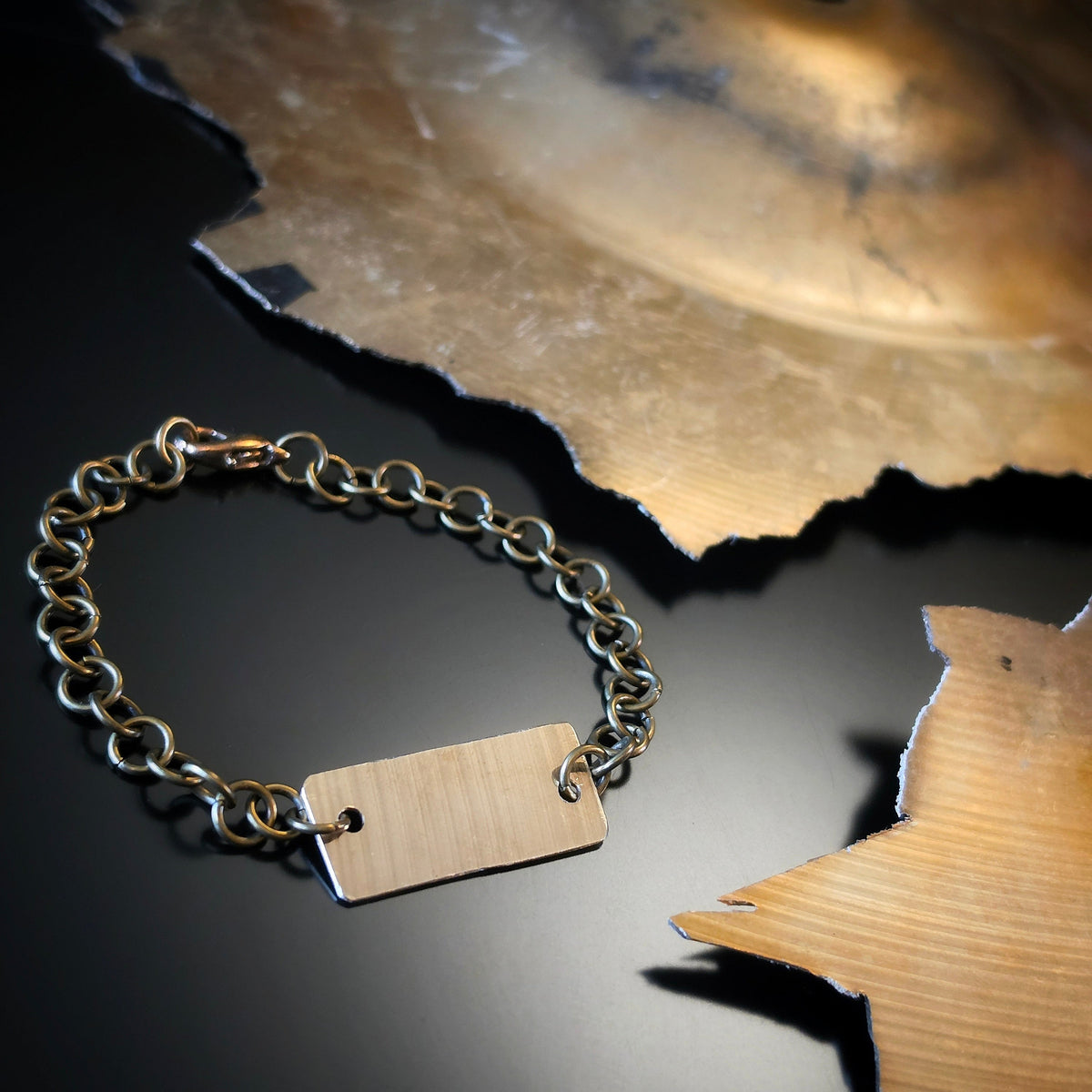 Closeup of Upcycled Cymbal Piece Chain Style Bracelet next to a broken Cymbal