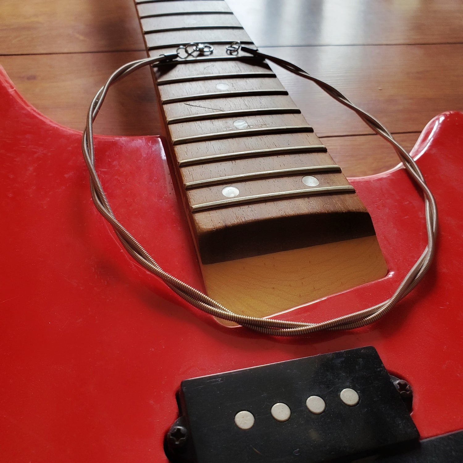 electric bass guitar string chain lying on a red bass