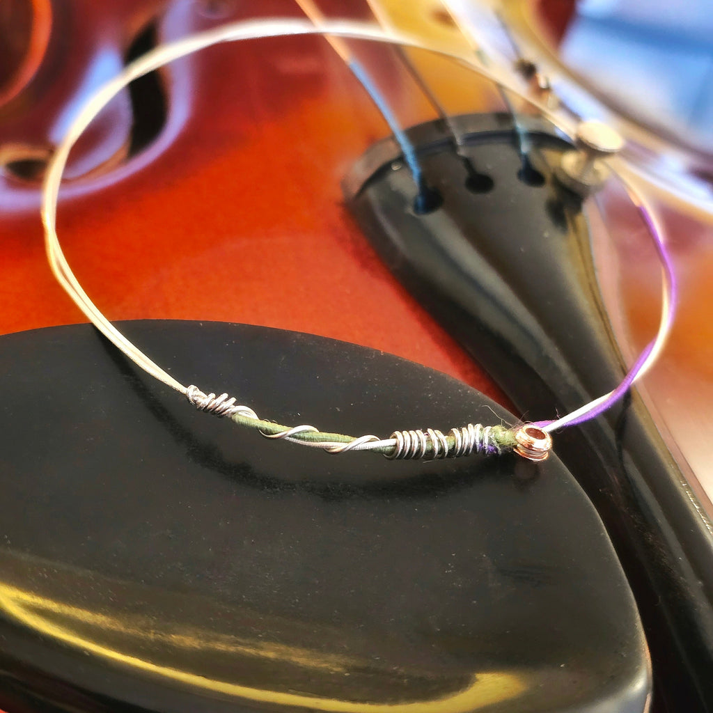 Green and purple violin string bangle on violin