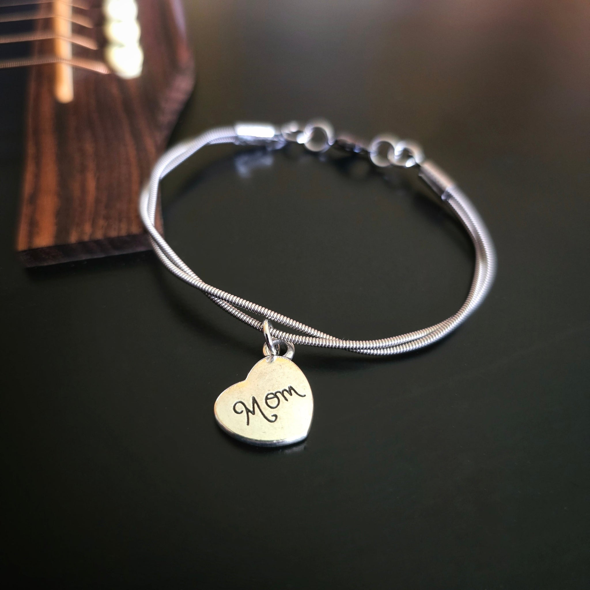 Guitar String Mom Charm Bracelet on Black Guitar