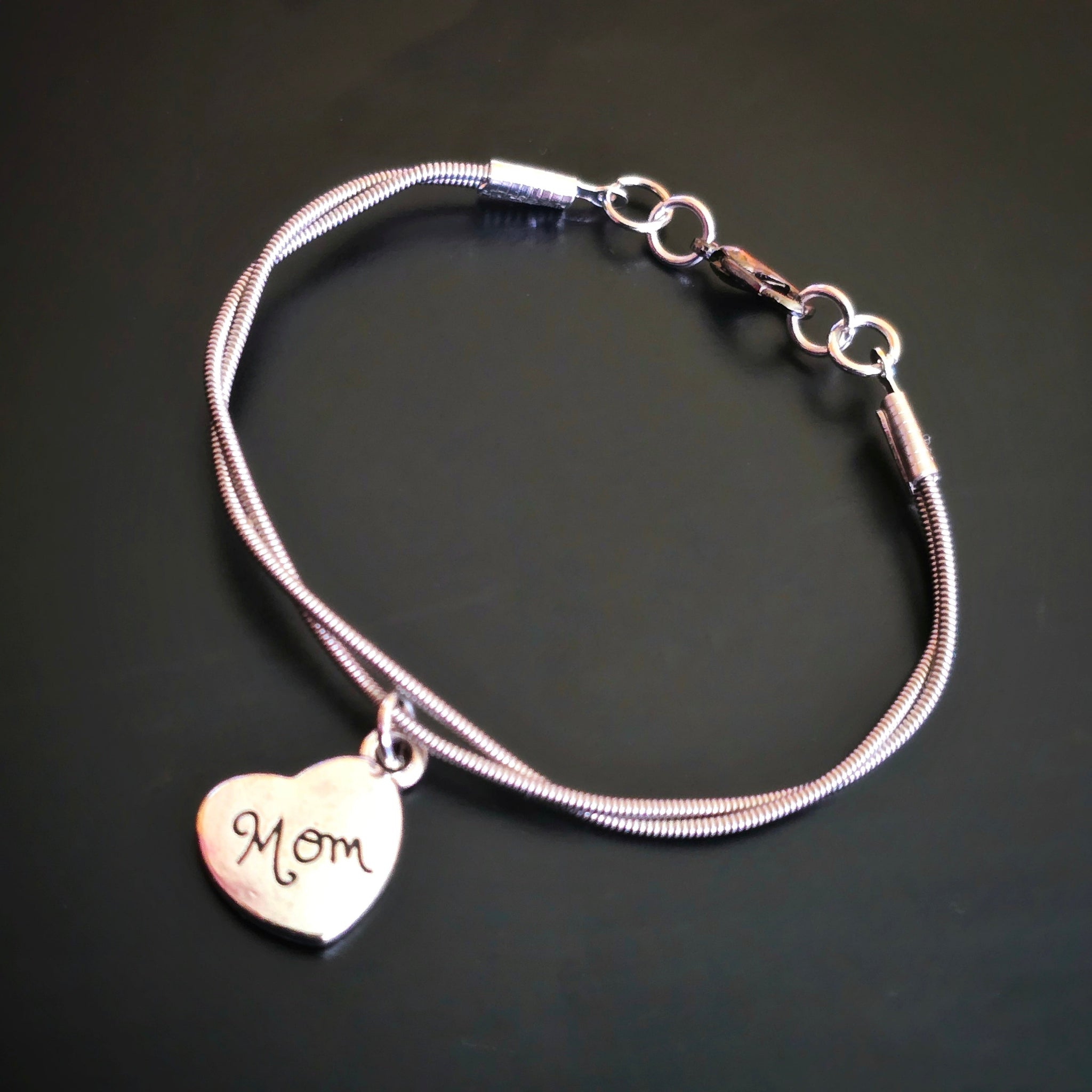 Guitar String Mom Charm Bracelet on black background
