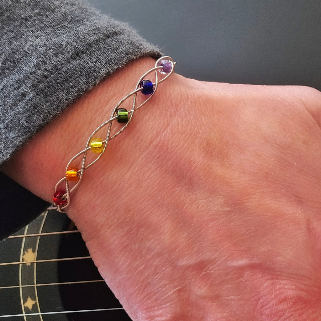 Hand on Guitar Neck LGBT Pride Bracelet with Braided Guitar Strings
