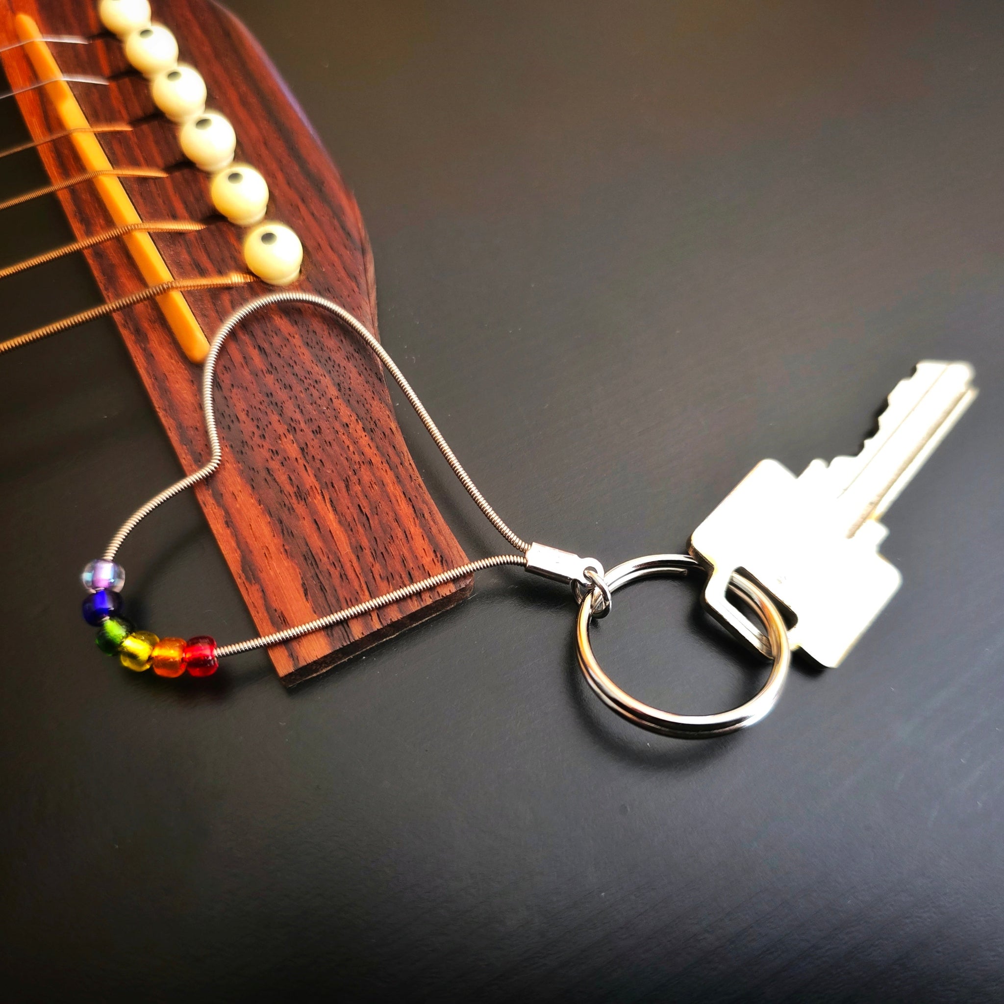 LGBTQ Pride Heart Shaped Keyring with Key on Black Guitar