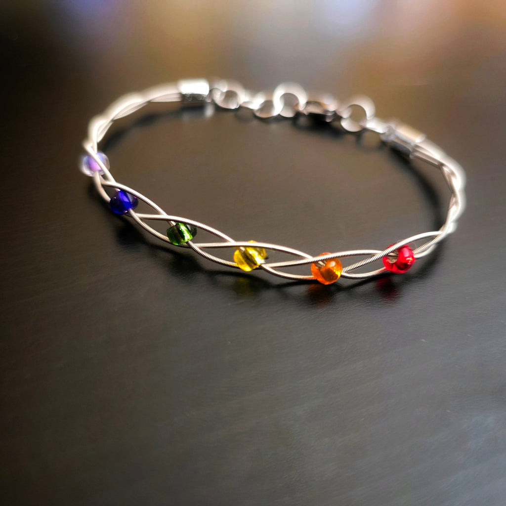 LGBT Pride Bracelet with Braided Guitar Strings on Black Background