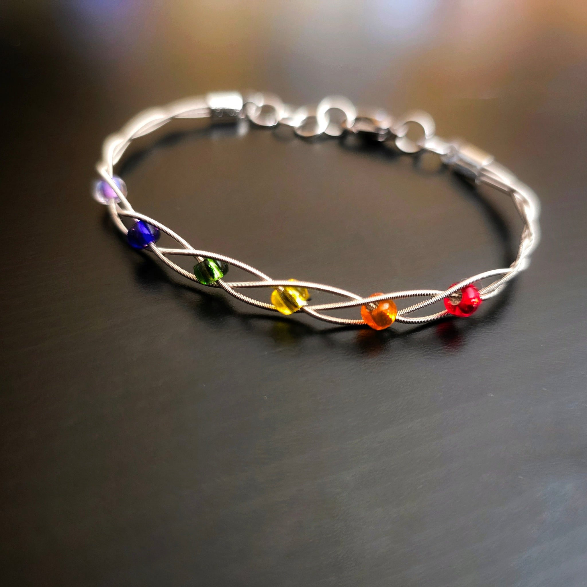 LGBT Pride Bracelet with Braided Guitar Strings on Black Background