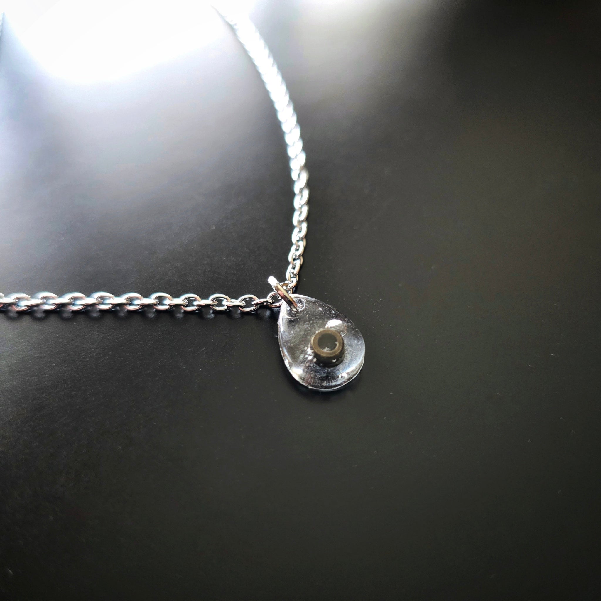 Side Close-up of Black Ballend Teardrop Resin Necklace on Black Guitar