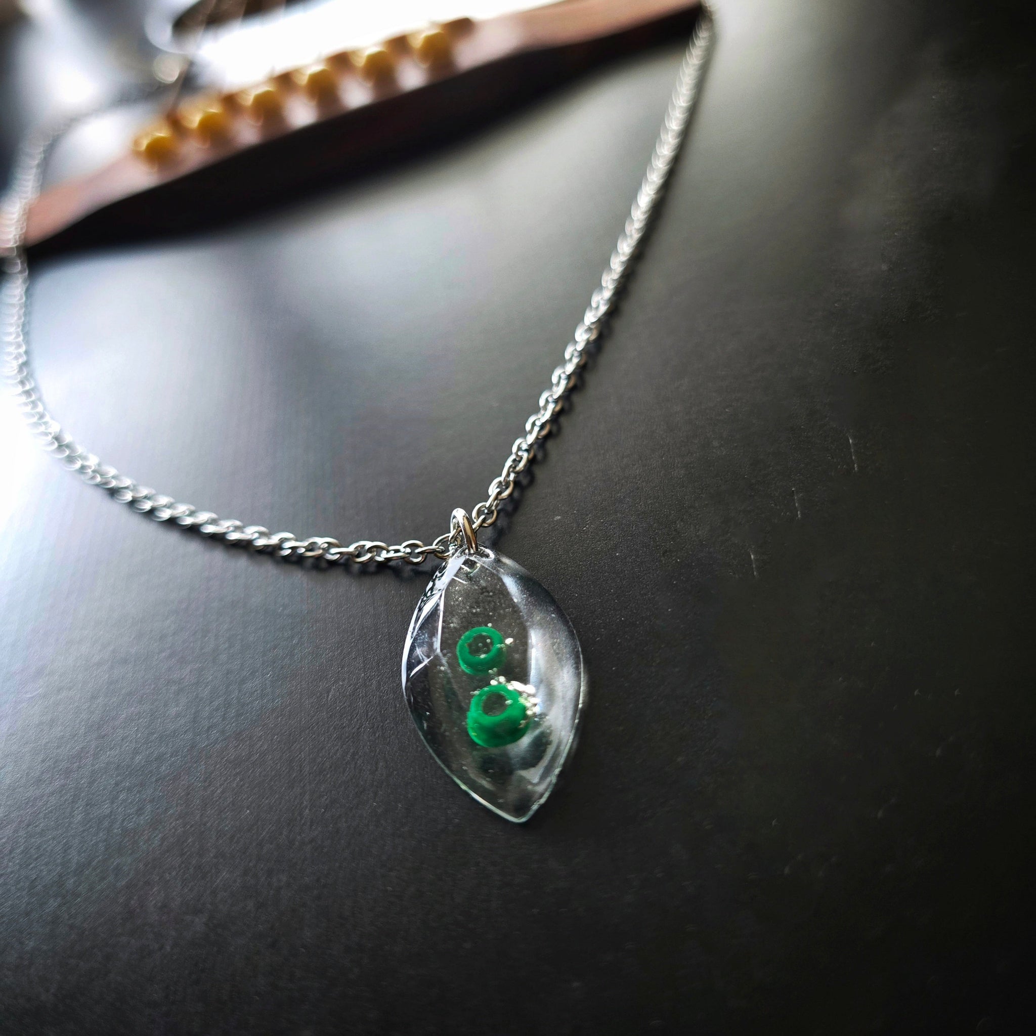 Side View of Marquise Shaped Resin Pendant with Green Guitar String Ballends