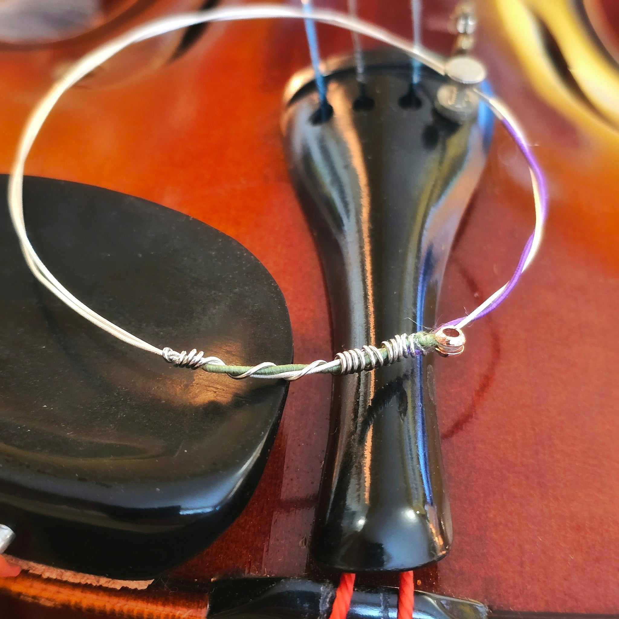 Side view of green and purple violin string bangle